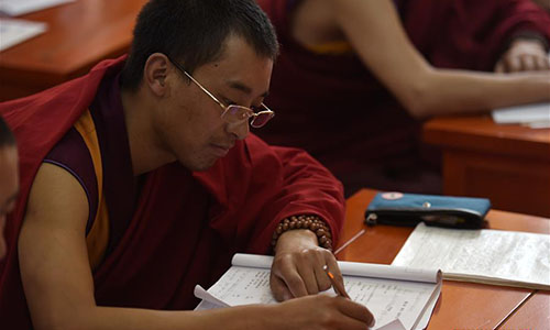  A monk takes notes during a lesson at Qinghai Tibetan Buddhism College in Guide County, northwest China's Qinghai Province, Nov. 16, 2016. The first batch of 120 monks have started their four-year full-time study at the newly-opened Tibetan Buddhism college recently. (Xinhua/Zhang Hongxiang)