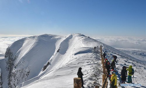 Tourists view the snowy scenery at the peak of Changbai Mountain in northeast China's Jilin Province, Dec. 15, 2016. (Xinhua/Lin Hong)