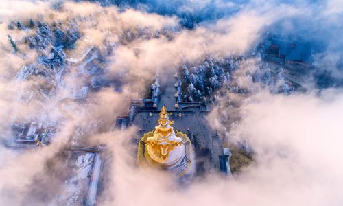 Mount Emei in southwest China’s Sichuan Province is shrouded in ethereal-like sea of clouds recently, giving tourists there a spectacular view. An aerial photo shows the golden peak of the Buddhist statue on the mountain peeking through the clouds, giving the illusion that it’s floating there in the sky. Photo: Chinanews.com