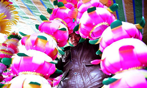 A villager checks a newly-made lantern in Nan'antou village of Jiaocun town in Lingbao, Central China's Henan province, Feb 8, 2017. Villagers of more than 100 families in Nan'antou are busy making lanterns to ensure market supply of the Lantern Festival. (Photo/Xinhua)