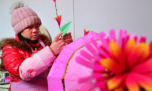 A villager checks a newly-made lantern in Nan'antou village of Jiaocun town in Lingbao, Central China's Henan province, Feb 8, 2017. Villagers of more than 100 families in Nan'antou are busy making lanterns to ensure market supply of the Lantern Festival. (Photo/Xinhua)