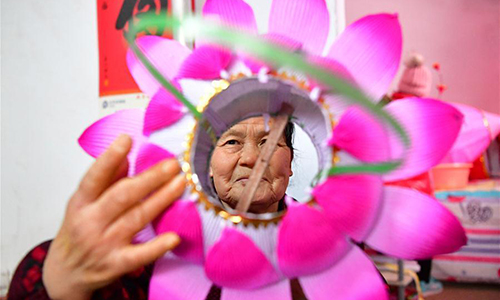 A villager checks a newly-made lantern in Nan'antou village of Jiaocun town in Lingbao, Central China's Henan province, Feb 8, 2017. Villagers of more than 100 families in Nan'antou are busy making lanterns to ensure market supply of the Lantern Festival. (Photo/Xinhua)