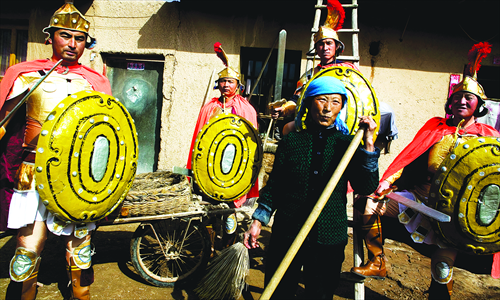Local villagers dressed in armors stand in front of a house. Photo: IC