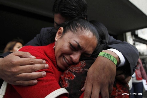 Residents react in front of Venezuela's Embassy to Ecuador, after the news of Venezuelan President Hugo Chavez's death was released, in Quito, Ecuador, on March 5, 2013. Venezuelan President Hugo Chavez died on March 5. (Xinhua/Santiago Armas)