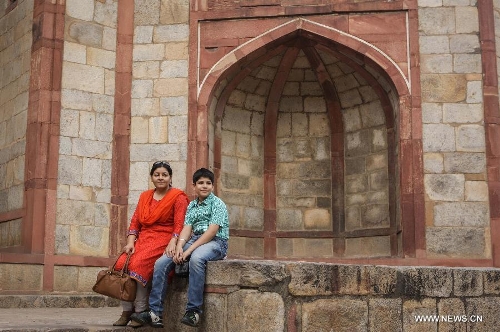 Tourists visit Humayun's Tomb in New Delhi, capital of India, May 12, 2013. Humayun's Tomb, located in east New Delhi, was built in 1569 to 1570 by Humayun's widow. As a precursor to the Taj Mahal, it stands on a platform of 12,000 square meters and reaches a height of 47 meters. The earliest example of the Persian influence in Indian architecture, the tomb itself is in the center of a large garden, surrounded by 12 hectares of gardens with pools joined by channels. The tomb brought Persian style to Delhi, but the two-tone combination of red sandstone and white marble is local, which shows the merging of different cultures. Humayun's Tomb was inscribed on the World Heritage List by the United Nations Educational, Scientific and Cultural Organization in 1993. (Xinhua/Zheng Huansong) 