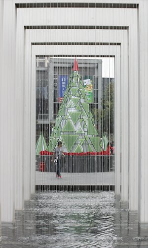 A passer-by looks at the 6.5-meter glass bead Christmas tree at LifeHub @ Jinqiao. Photo: Cai Xianmin/GT