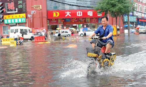 A motorcycle drives in heavy rain in Beijing, capital of China, July 21, 2012. Photo: Xinhua