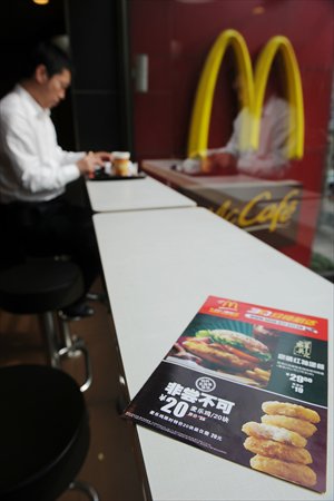 A leaflet on a table in McDonald’s advertises a discount on chicken McNuggets at a Shanghai branch on Monday. The fast food giant slashed prices by more than 40 percent on a chicken item, offering 20 McNuggets for 20 yuan ($3.17) while emphasizing its food was safe. Photo: AFP