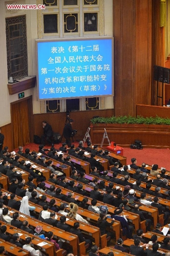  Deputies vote on a draft resolution on the plan of institutional reform and functional transformation of the State Council during the fourth plenary meeting of the first session of the 12th National People's Congress (NPC) at the Great Hall of the People in Beijing, capital of China, March 14, 2013. Chairman, vice-chairpersons, secretary-general and members of the 12th NPC Standing Committee, president and vice-president of the state, and chairman of the Central Military Commission of the People's Republic of China will also be elected here on Thursday. (Xinhua/Wang Song)