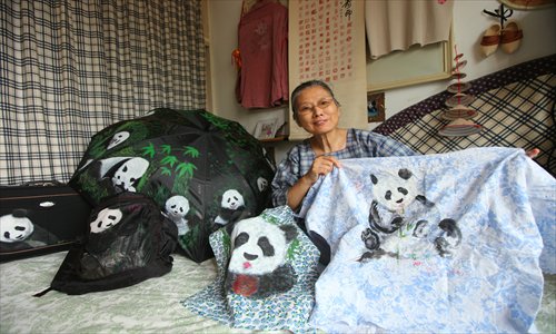 Lin Weizhou poses with fabrics, handbags and umbrella with images of pandas on them. Photos: Cai Xianmin/GT