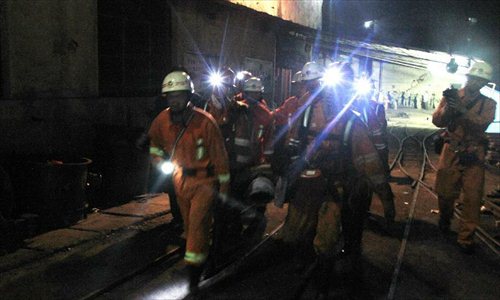 Rescuers carry a survivor at Xiaojiawan Coal Mine in Panzhihua City, southwest China's Sichuan Province, Aug. 30, 2012. The death toll in the gas explosion that occurred Wednesday afternoon at the coal mine has climbed to 19 and 28 others remain missing. A total of 154 miners were working underground at the Xiaojiawan Coal Mine when the blast occurred. Photo: Xinhua
