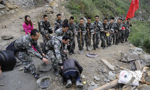 Zhang’s cousin kneels down to express his gratitude for soldiers from the People's Liberation Army (PLA) Chengdu Military Area Command (MAC) on April 23. Photo: Li Hao/GT