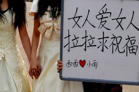 Lesbian lovers Xixi and Xiaoyu held a wedding ceremony in a park in Lanzhou, northwest China's Gansu province on April 15, 2013. Wearing wedding dress and holding a sign reading 