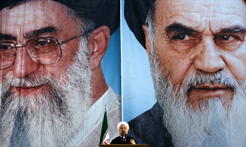 Iranian President Hassan Rouhani delivers a speech under portraits of Iran's supreme leader, Ayatollah Ali Khamenei (left) and the founder of the Islamic Republic, Ayatollah Ruhollah Khomeini, on the eve of the 25th anniversary of Khomeini's death at his mausoleum in Tehran on Tuesday. Photo: AFP