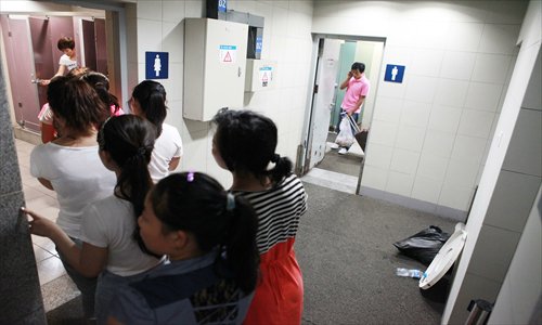 Women line up at the restroom at the Xidan subway station in Beijing on Thursday, while the men's room is almost empty. Activists said the scene, commonly seen at public restrooms across China, is an instance of gender discrimination by restroom designers. Photo: Li Hao/GT

