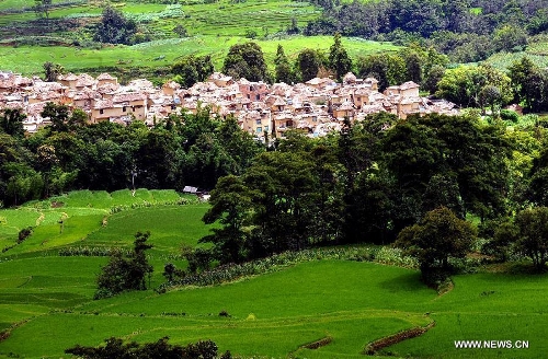 Photo taken on June 29, 2013 shows the village buildings and terraced fields in Yuanyang County of Honghe Prefecture in southwest China's Yunnan Province. The UNESCO's World Heritage Committee inscribed China's cultural landscape of Honghe Hani Rice Terraces onto the prestigious World Heritage List on June 22, bringing the total number of World Heritage Sites in China to 45. (Xinhua/Chen Haining) 