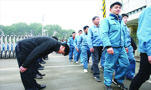 Managers of a factory in Taizhou, East China's Zhejiang Province bow to returning workers on Monday, the first work day after the factory's Chinese lunar new year holidays. The company has held such welcome-back ceremonies for the first work days after every major holiday since 2008, in a bid to retain employees when it is increasingly difficult for small and medium-sized manufacturers to recruit workers in China. Photo: CFP