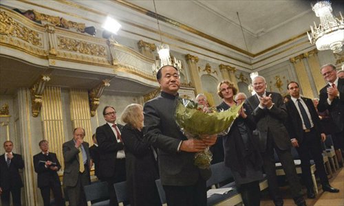 Chinese writer and 2012 Nobel Literature Prize winner Mo Yan receives a bunch of flowers after his lecture at Swedish Academy in Stockholm, capital of Sweden on December 7, 2012. Photo: Xinhua
