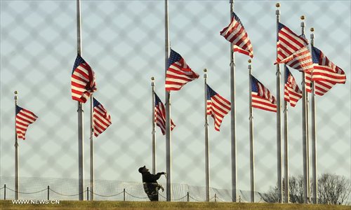 A National Park Service employee lowers a flag at the base of the Washington Monument to half staff to honor the victims of the Connecticut shooting incident in Washington D.C., capital of the United States, Dec. 14, 2012. US President Barack Obama on Friday ordered US flags to be flown at half-staff at the White House and all public buildings and grounds, as a mark of respect for the victims of a deadly shooting spree at Sandy Hook Elementary School in Newtown, Connecticut, which took place earlier in the day. Photo: Xinhua
