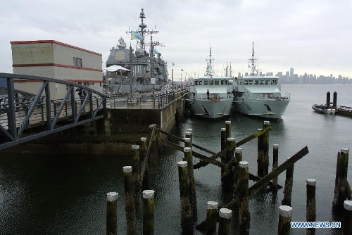 The Royal Canadian Navy Orca class Patrol Training Crafts (R) and U.S. Navy guided-missile cruiser USS Lake Champlain are seen at bay during a media presentation in North Vancouver, Canada, on April 27, 2013. Approximately 1,000 Canadian and American sailors are in Vancouver to meet the public and media to bring the Navy to the Canadians. (Xinhua/Sergei Bachlakov) 