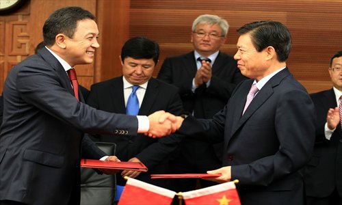 China's Vice-Minister of Commerce Zhong Shan (right) shakes hands with Karashev Aaly Azimovich, First Deputy Prime Minister of Kyrgyzstan, after signing a  cooperation agreement on July 31, 2012. Photo: IC