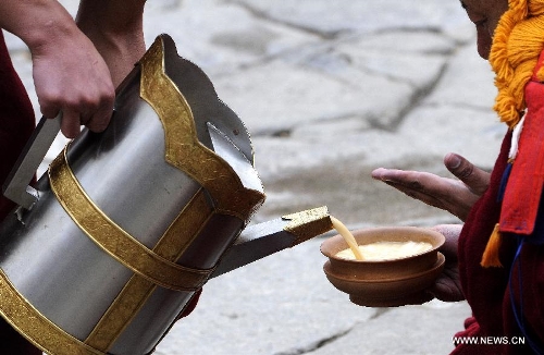Drink is provided for monks at the ceremony of defending dissertations for Gexe Lharampa, the highest academic degree in Tibetan Buddhism studies, at the Jokhang Temple in Lhasa, capital of southwest China's Tibet Autonomous Region, April 5, 2013. Eight laureates of Gexe Lharampa were awarded here on Friday after they passed tests and defended their dissertations. Gexe means knowledgeable and Lharampa is the highest among the four ranks in the Gexe system. (Xinhua/Chogo)  
