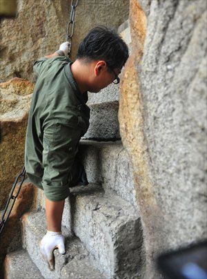 Chen Zhou, a legless singer from East China's Shandong Province, climbs Huashan Mountain in Northwest China's Shaanxi Province on Sunday. It took Chen two days to reach the peak of the mountain. Photo: CFP