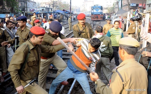 Police try to disperse activists who blocked a railway during a nationwide strike in Guwahati, capital city of India's northeastern state of Assam, Feb. 20, 2013. Indian unions started a two-day strike Wednesday to protest high inflation, privatization of public sector and alleged anti-labor policies by the Congress-led government. (Xinhua/Stringer) 