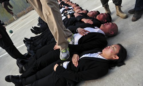 Trainees hold their breath while being stepped on during the training. Photo: Yang Yifan/Tencent News