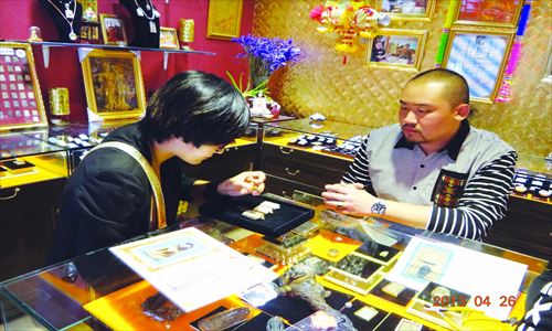 A customer selects Buddha amulets in a shop in Beijing. Photos: Wei Xi/GT