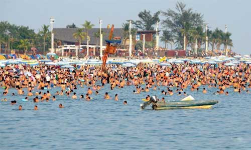 Tourists amuse themselves in the Yintan bathing beach in Beihai, south China's Guangxi Zhuang Autonomous Region, Oct. 1, 2012. As the eight-day National Day holiday came, hundreds of millions of tourists crowded into scenery spots, resorts and other tourism destinations scattered across the country. Photo: Xinhua