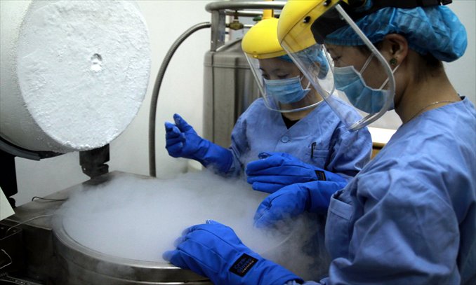Two workers store sperm in a liquid nitrogen tank kept at below -196 C in a sperm bank in Shenyang, Liaoning Province. Photo: CFP