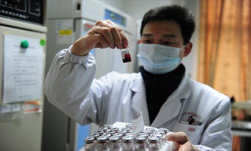 A researcher checks on the blood sample in a test tube in Jiangxi Province. Photo: CFP