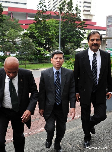 Former chief of the Singapore Civil Defence Force Peter Lim (C) arrives with his lawyers at the subordinate court for a hearing in Singapore, Feb. 18, 2013. Peter Lim was charged with corruption for allegedly obtaining sexual favours from three women between May 2010 and November 2011 for helping them with government contracts. (Xinhua/Then Chih Wey) 
