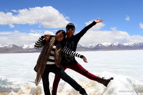 Girls of Tibetan ethnic group pose for a photo next to the icy lake Nam Co located at the boundary of Damxung and Baingoin counties, southwest China's Tibet Autonomous Region, on May 12, 2013. Lake Nam Co, the highest saltwater lake of the world at 4,718 meters above the sea level, is regarded as a sacred lake in Tibetan Buddhism. (Xinhua/Chen Tianhu)&nbsp; 