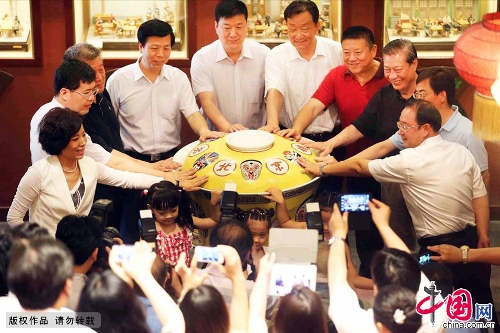 A 200kg ceramic tea bowl debuted June 30 at the Laoshe Teahouse, a world-famous Chinese folk teahouse in Beijing. The huge bowl, an enlarged version of the classical ceramic bowls with yellow lids used at the teahouse, was made by craft masters in Jingdezhen, which is known as the Porcelain Capital of China. The 75x88 cm-bowl is currently the biggest of its kind in the world. Its makers have applied to have it listed in the Guinness Book of World Records. The party at which the bowl debuted was held to mark the tenth anniversary of the death of teahouse founder Yin Shengxi.(Photo:China.org.cn)