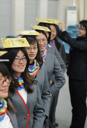 Young women at a finishing school in Yangzhou, Jiangsu Province, work on their posture and smiling on the eve of the 2012 International Women's Day. Photo: IC
