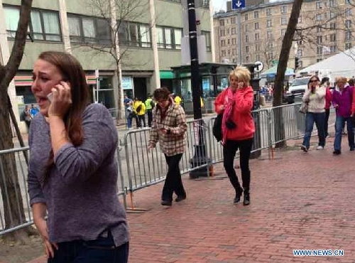 People react following explosions happened in Boston, the United States, April 15, 2013. Three explosions occurred near the Boston Marathon finish line, killing at least 2 people, local media reported. (Xinhua/Zhao Xirong) 