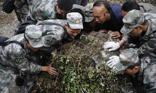 Soldiers from the People's Liberation Army (PLA) Chengdu Military Area Command (MAC) try to move a huge rock blocking the way to Goushan village, Baoxing county, after a landslide on April 23. Photo: Li Hao/GT
