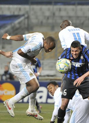 Marseille's Andre Ayew (left) heads home the winning goal against Inter's Lucio. Photo: CFP
