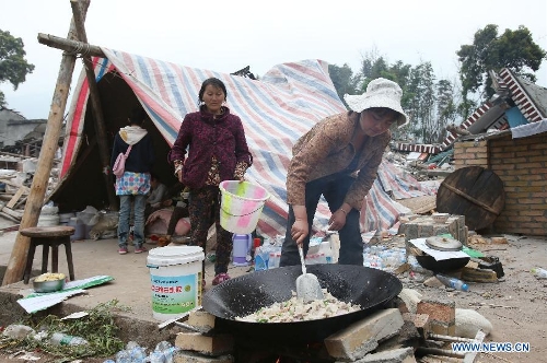 Displaced villagers cook meals in Gucheng Village, Longmen Town, Lushan County, southwest China's Sichuan Province, April 21, 2013. Military and civilian rescue teams are struggling to reach every household in Lushan and neighboring counties of southwest China's Sichuan Province, badly hit by Saturday's strong earthquake. (Xinhua/Jin Liwang) 