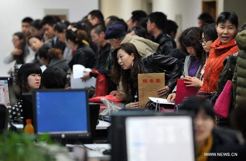 Citizens conduct housing transactions at the Housing Transaction Center in Shijiazhuang, north China's Hebei Province, March 8, 2013. Secondhand housing transaction surges in the city these days as buyers and sellers are rushing to 