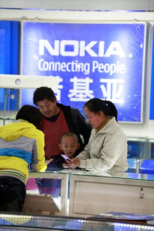 Consumers pick out cellphones at an electronics outlet in Jilin, Jilin Province. Photo: CFP
