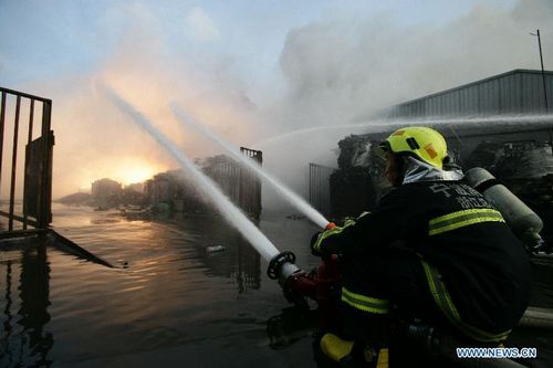 Firefighters hose down fire at a workshop in Zhenhai District of Ningbo, East China's Zhejiang Province, August 1, 2012. The fire broke out in a renewable resources plant in Ningbo at about 5 pm Wednesday, leave one person dead and 18 others injured. The investigation of the reason of the fire is underway. Photo: Xinhua
