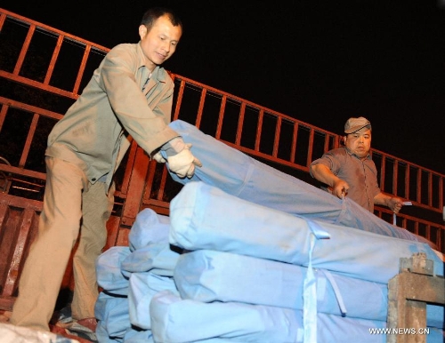 Working staff unload the tent toilets from a truck to load onto a train at the Zhengzhou Railway Station in Zhengzhou, capital of central China's Henan Province, April 22, 2013. A total of 200 tent toilets were sent to the earthquake jolted Ya'an City of southwest China's Sichuan Province on Monday. (Xinhua/Li Bo) 