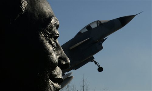 A statue of Wu Daguan (left), who is known as the father of China's military aviation industry, is displayed next to a Chinese produced J-10 fighter jet in Beijing on Thursday. Photo: AFP
