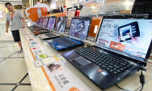  A salesperson stands by a counter at a shopping mall in Shanghai. The government is likely to add laptops, photocopiers and printers to the list of subsidized product items that meet a certain level of energy-saving requirements, the Beijing News reported Wednesday, citing Vice Minister of Industry and Information Technology Su Bo. In September 2012, desktop computers were added to the list, with the government offering 260 yuan ($42.35) in subsidies for people purchasing energy-saving desktops. Photo: IC