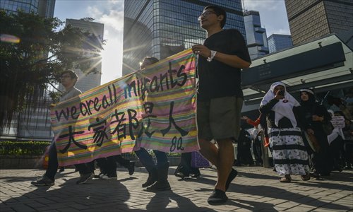 Migrant workers from Southeast Asia hold a banner as they attend a workers' rights rally in Hong Kong. About 1,000 migrant domestic workers from Southeast Asia rallied in Hong Kong on Sunday to mark International Migrants Day and push for better working conditions and higher wages. Photo: AFP