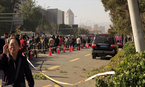 Pedestrians and vehicles draw along a street on Wednesday morning as police cordoned off the site of a series of explosions by homemade bombs near the provincial Party office buildings in Taiyuan, Shanxi Province. The blasts killed one and injured eight. Photo: IC
