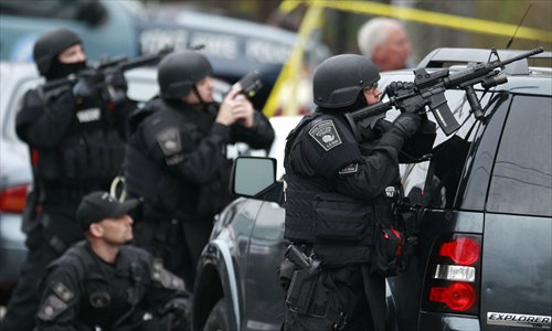 Police in tactical gear surround an apartment building while looking for a suspect in the Boston Marathon bombings in Watertown, Massachusetts on Friday. Photo: IC